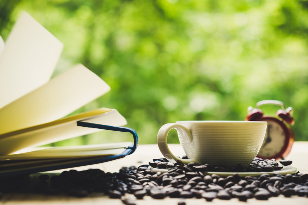 taza-de-cafe-portatil-blanco-granos-de-cafe-y-despertador-en-un-escritorio-de-tablon-de-madera-vista-superior_2379-306